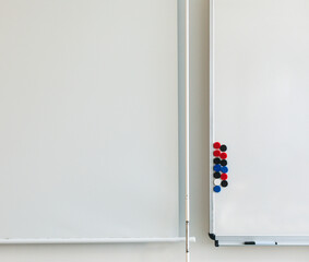 Leeres Whiteboard mit Magneten und Beamer Leinwand in einem Schulungsraum