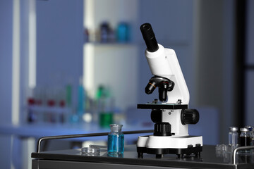 Modern medical microscope on metal table in laboratory, space for text