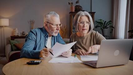 Elderly family couple compares and discusses utility bills - Powered by Adobe