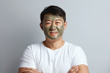 Asian Man Face Mask. Skin Care Procedure For Man. Model Applying Facial Mask During Spa Relaxation. Cosmetology Mud For Face care