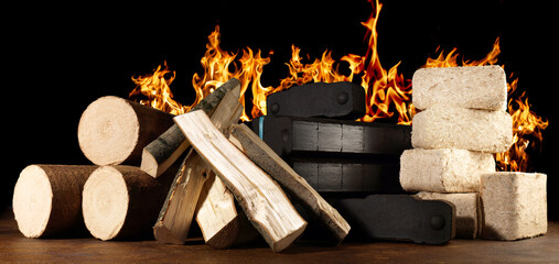 Brennholz, Kohle und Holzbriketts und Holzscheite - Kaminholz mit Feuer, Flammen auf schwarzem...