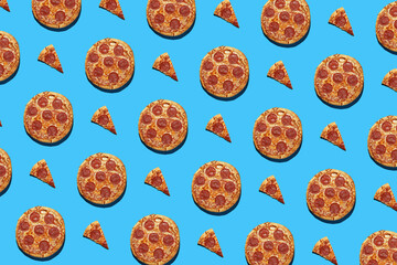 A hard light pattern of whole and cut salami pizza pieces on a seamless bright blue background, top view