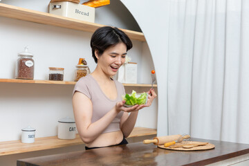 Obraz na płótnie Canvas Portrait of a happy playful girl eating fresh salad from a bowl.
