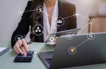 Female businessman working with holding a pen and using a calculator to calculate the numbers of...