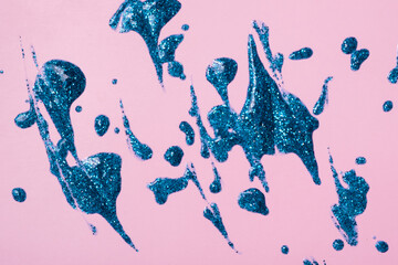 Blue glitter smear on colored background top view. Christmas glitter element