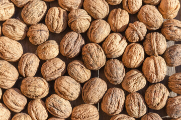 Top view of walnuts in shells scattered in an even layer