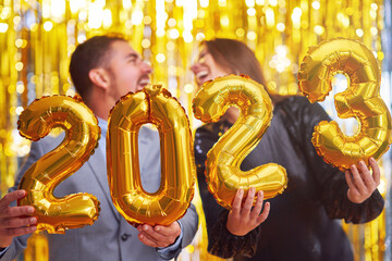 Fototapeta na wymiar Couple at new year eve party with gold balloons