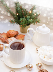 Obraz na płótnie Canvas Winter, Christmas, New Year decoration composition, concept, background. White Mug, cup of hot tea, coffee, meringue, knitted plaid. Christmas lights. Christmas mood morning. Xmas greeting card.