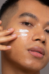 Close-up of person applying moisturizer on face