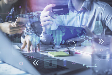 Double exposure of man and woman on-line shopping holding a credit card and map hologram drawing. International E-commerce pay on-line concept.