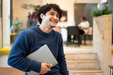 Smiling businessman holding laptop in office © Cultura Creative