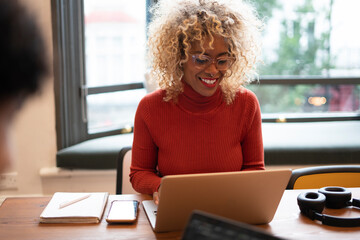 Smiling businesswoman working on laptop in office