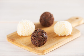 Sweets truffles with chocolate and coconut on a board, traditional brazilian sweets.