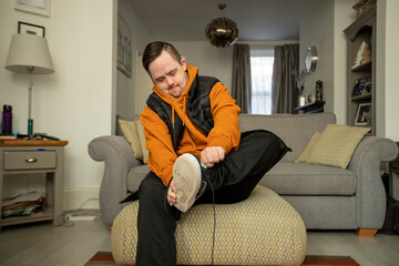 Man sitting in living room getting dressed