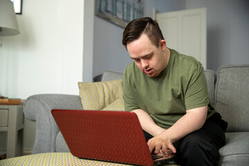 Man sitting on sofa and using laptop