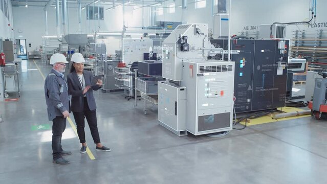 Factory Digitalization: Two Industrial Engineers Use Tablet Computer, AI Big Data Analysis. Visualization of High-Tech Facility into 3D Rendered Neural Network. Industry 4.0 Machinery Manufacturing