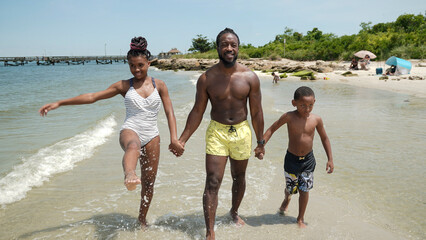 USA, Father with children walking on beach © Cultura Creative