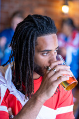 Young man drinking beer in pub