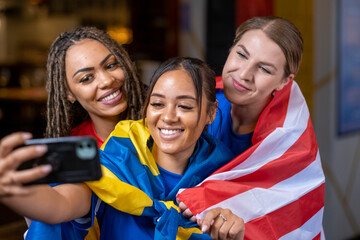 Women dressed in national flags for world cup competition taking selfie