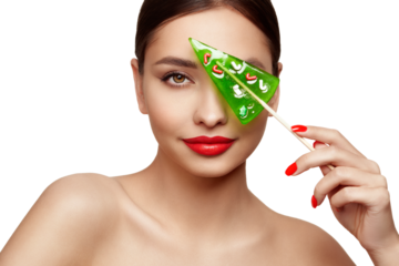 Beauty model girl eating Christmas tree shape lollipop.  Beautiful young woman with clean fresh skin. Girl beauty face care. Facial treatment. Cosmetology, beauty and spa. Red nails manicure