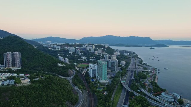  Aerial drone forward moving shot over the Chinese University of Hong Kong (CUHK), Hyatt Regency and CUHK Medical Centre in Hong Kong at sunrise.
