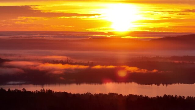 Aerial Flight of wilderness lake view illuminated by golden hour sunset