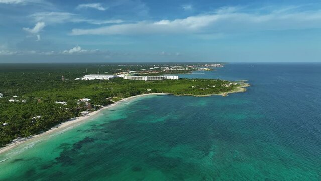 Aerial view overlooking the sunny coastline of Xpu Ha, Mexico - descending, pull back, drone shot