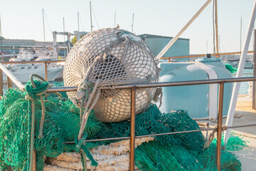 Redes y aparejos de pesca en Monopoli, Puglia, Italia. Barco de pesca profesional fondeado en la...