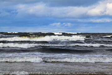 Fototapeta na wymiar Waves on the sea on windy cloudy day. Selective focus