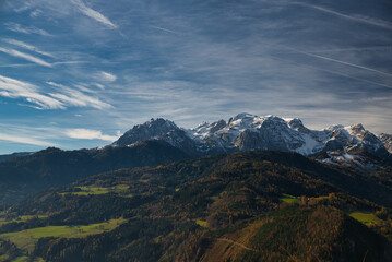 der Hochkönig mit frischen Schnee im Herbst mit Hagengebirge im Vordergrund unter blau Himmel mit wolken