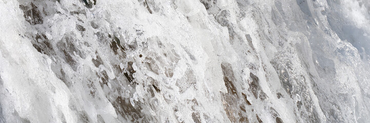 Frozen ice stalagmite in snow with ice in cave