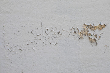 Texture surface painted with white paint with cracks and chips, peeling oil paint on a stone surface close-up background texture
