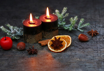 Fototapeta na wymiar Romantische Advents und Weihnachtsdekoration mit brennenden Kerzen,Tannenzweigen, Orangenscheiben und Zimtstangen.