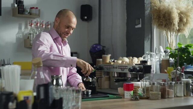 A professional barista presses coffee in a templer. The process of making espresso in a cafe. Fragrant morning cappuccino drink. High quality 4k footage