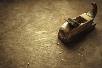 An old wooden plane on the table. Wooden planing on wood.Carpenter's tool.