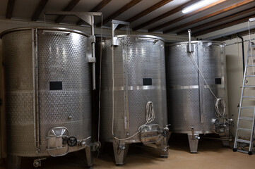 Stages of wine production from fermentation to bottling, visit to wine cellars in Burgundy, France. Steel vats for fermentation.