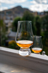 Glass of single malt scotch whisky served on old window sill in Scottisch house with view on old part of Edinburgh, Scotland, UK