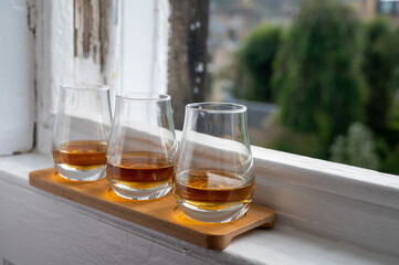 Flight of single malt scotch whisky served on old window sill in Scottisch house with view on old part of Edinburgh, Scotland, UK