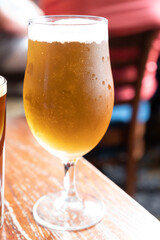 Pint glass of british light pilsner ot lager beer served in old vintage English pub