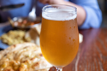 Pint glass of british light pilsner ot lager beer served in old vintage English pub
