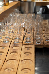 Emply whisky glasses served in flights on wooden boards in old whiskey bar in Edinburgh, UK