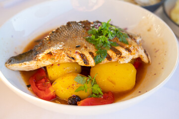 Provence cuisine, filet of seabass white fish served with potatoes, tomatoes and .Bouillabaisse jus in French restaurant