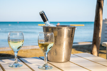 Drinking of cold white wine in beach bar, summer holidays, relax on sandy beach