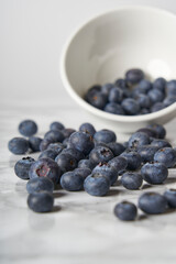 A group of fresh blueberries on a white and black marble table. 