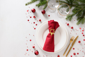 Christmas table setting with red decorations, wine glasses and champagne on white background. View...