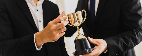 Cheerful business team winning  trophy