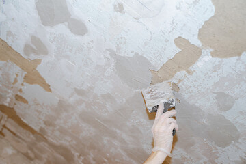 a worker puttying holes in the walls with a tool