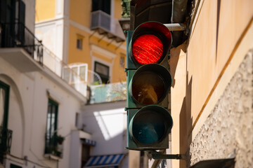Traffic light indicating “Red“ for “Stop!“ in the narrow main street “Via Pietro...