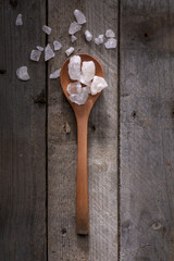 Wood spoon with slat rocks on rustic wood
