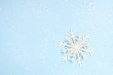 Beautiful decorative snowflake on white snow. blue background with space for text, greeting christmas card